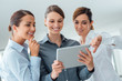 © stokkete - Female business team using a digital tablet