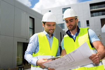 Wall Mural - Engineer and worker checking plan on construction site