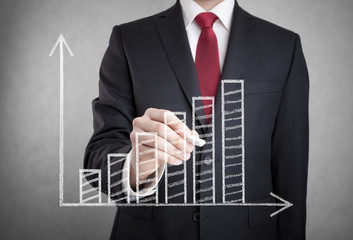 Businessman drawing a growing chart with chalk. 