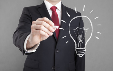 Wall Mural - Businessman drawing idea light bulb with chalk