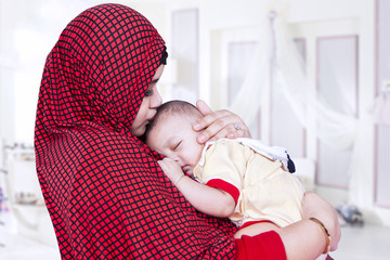 Wall Mural - Mother with veil kiss her baby in bedroom