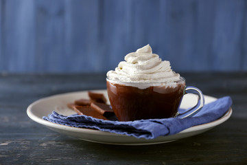 Wall Mural - Cup of coffee with cream on color wooden background