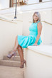 © toomler - beautiful girl in a turquoise dress posing on the steps, outdoor