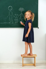 Wall Mural - Girl drawing on blackboard at school