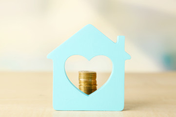 Canvas Print - Model of house with coins on bright background