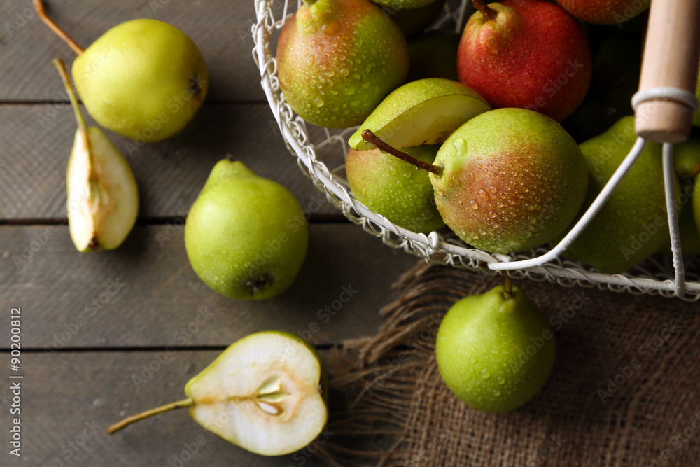 Ripe tasty pears in basket on table close up