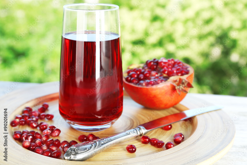 Fresh garnet juice with fruit on bright background