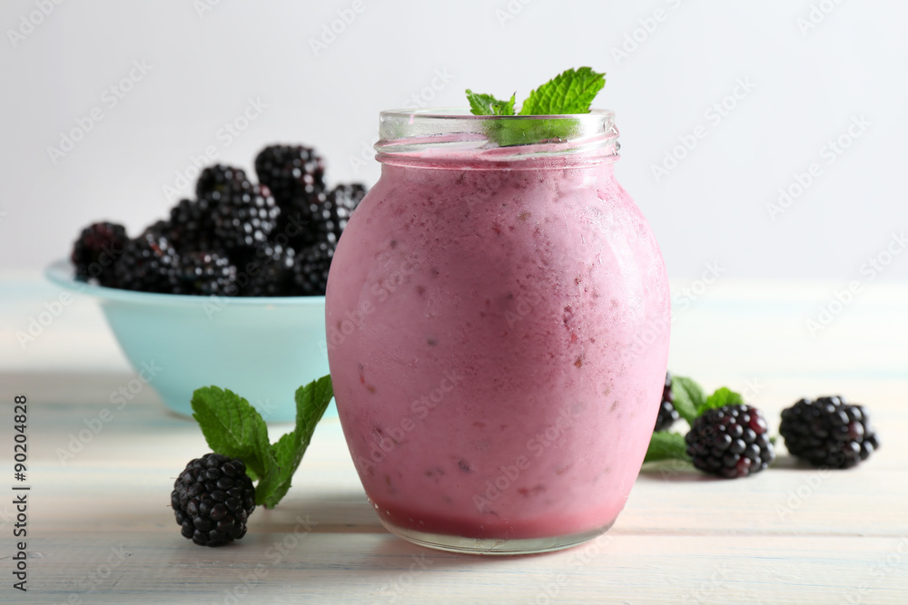Delicious berry smoothie with blackberries on wooden table close up