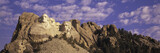 Fototapeta Sawanna - Panoramic image with white puffy clouds behind Presidents George Washington, Thomas Jefferson, Teddy Roosevelt and Abraham Lincoln at Mount Rushmore National Memorial, South Dakota