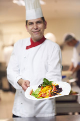 Wall Mural - chef in hotel kitchen preparing and decorating food