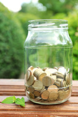 Poster - Coins in money jar on table outdoors