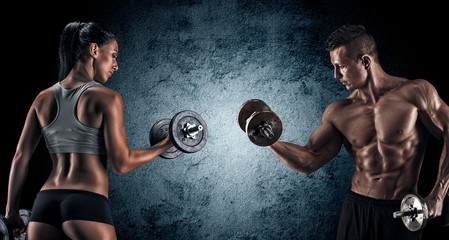 Wall Mural - Athletic man and woman with a dumbells.