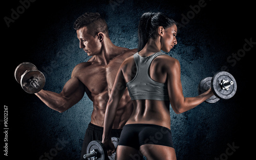 Obraz w ramie Athletic man and woman with a dumbells.