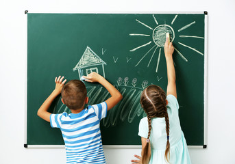 Wall Mural - Children drawing on blackboard at school