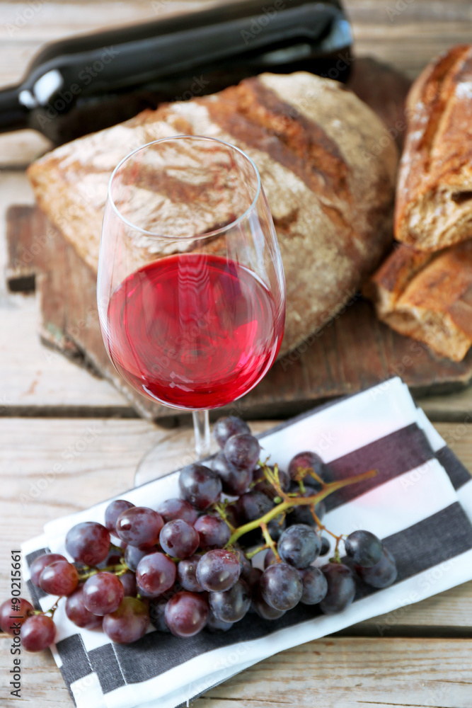 Still life of wine and bread on rustic wooden background