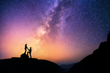 Wall Mural - love is in the air.romantic couple standing together holding hands in the mountains. beautiful milky