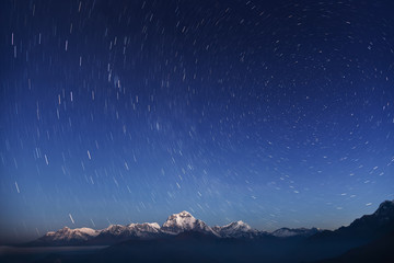 Wall Mural - night laconic landscape. starry sky over the snowy mountains.