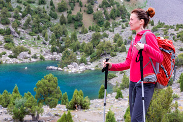 Female Hiker Looking into Far Portrait of pensive female hiker observing beautiful landscape with azure blue lake and rocky terrain of Fan Mountains