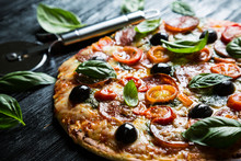 Pizza With Salami, Olives And Basil