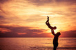 © altanaka - Father and son playing on the beach at the sunset time.