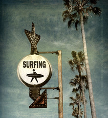 Wall Mural - aged and worn vintage photo of surfing sign on beach