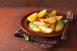 baked potato wedges in plate over brown rustic table