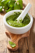 pesto sauce and ingredients over wooden background