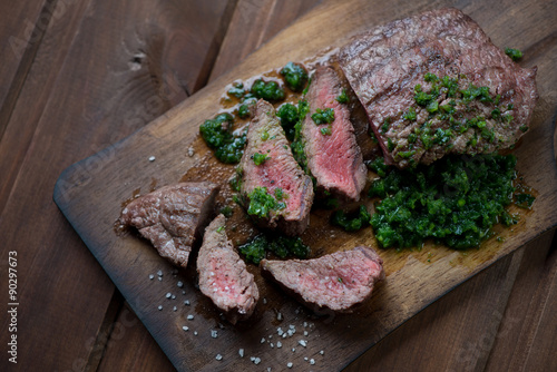 Sliced medium rare grilled beef barbecue steak with chimichurri Poster
