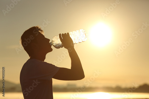 Fotografía Silueta del hombre de la aptitud del agua potable de una botella