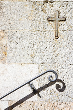 Iron Cross Snuggled In Stone With An Old Metal Handrail