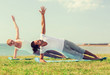 © Syda Productions - smiling couple making yoga exercises outdoors