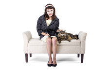 Woman In Retro Style Clothing Sitting And Petting A Brown Maine Coon Cat