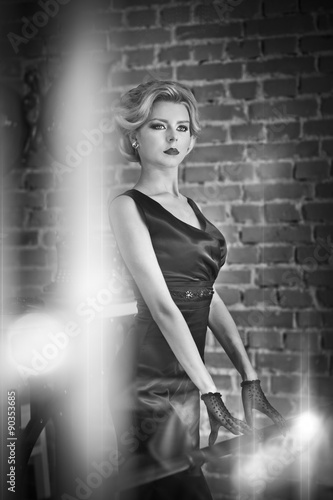 Young Beautiful Short Hair Blonde Woman In Black Dress Posing