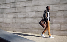 Street Fashion, Stylish African Man In Black Rock Leather Jacket With Bag Walking In Evening City