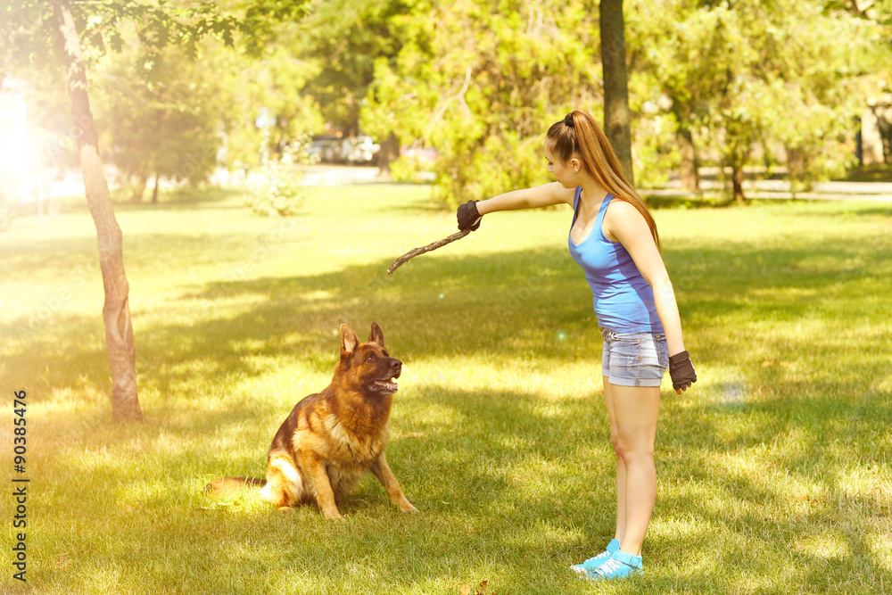Beautiful young girl with dog in park Stock Photo | Adobe Stock