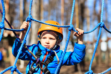 little boy climbing in adventure activity park