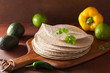 whole wheat tortillas on wooden board and vegetables
