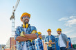© Syda Productions - group of smiling builders in hardhats outdoors