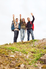 Canvas Print - group of smiling friends with backpacks hiking