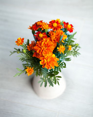 Marigolds flowers in vase on grey background