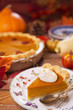Homemade pumpkin pie on a rustic table with autumn decorations