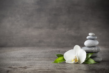 Poster - White orchid and spa stones on the grey background.