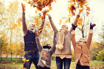 Wall Mural - happy family playing with autumn leaves in park