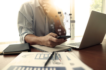 designer hand working and smart phone and laptop on wooden desk