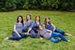 Group of pregnant women sitting on a grass