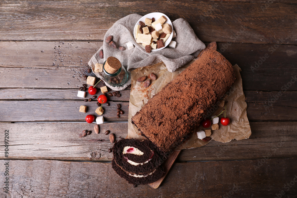 Chocolate roll with cream and berries on table close up
