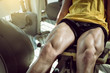© Alen Ajan - Man doing leg extension in gym