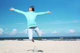 Fototapeta Fototapety z morzem do Twojej sypialni - Wakacje! Dziewczynka wysoko podskakuje na piaszczystej plaży