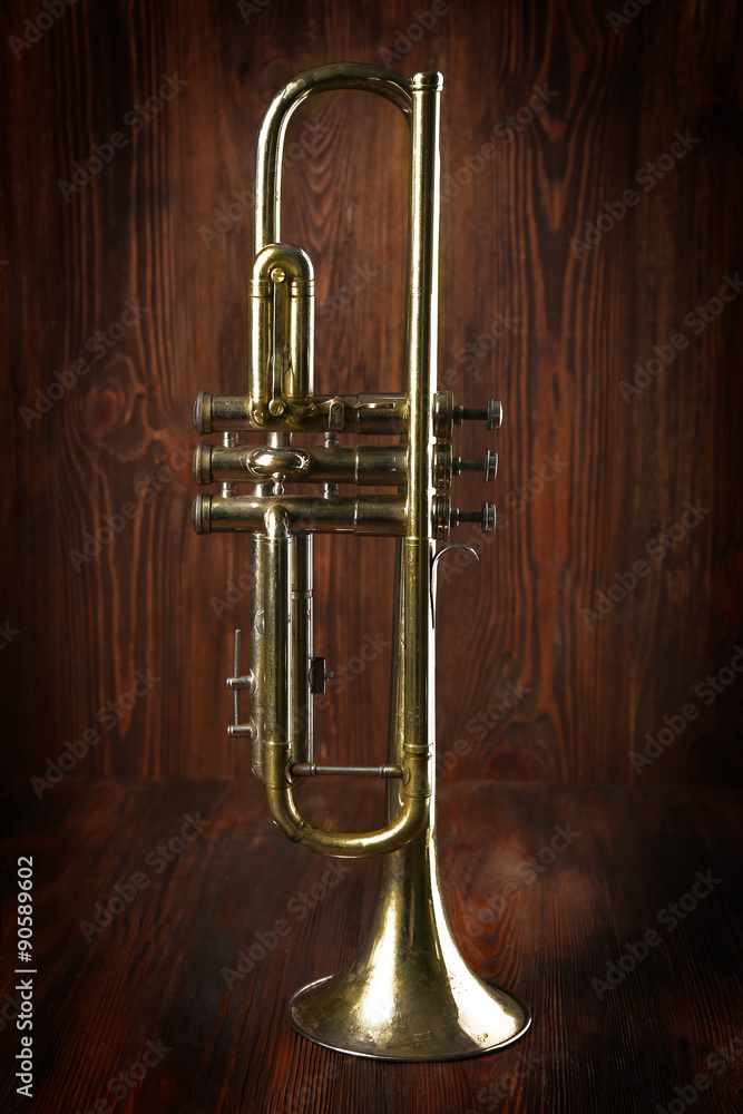 Silver trumpet on wooden background