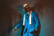 African american dandy man in blue suit and straw hat. Holding c